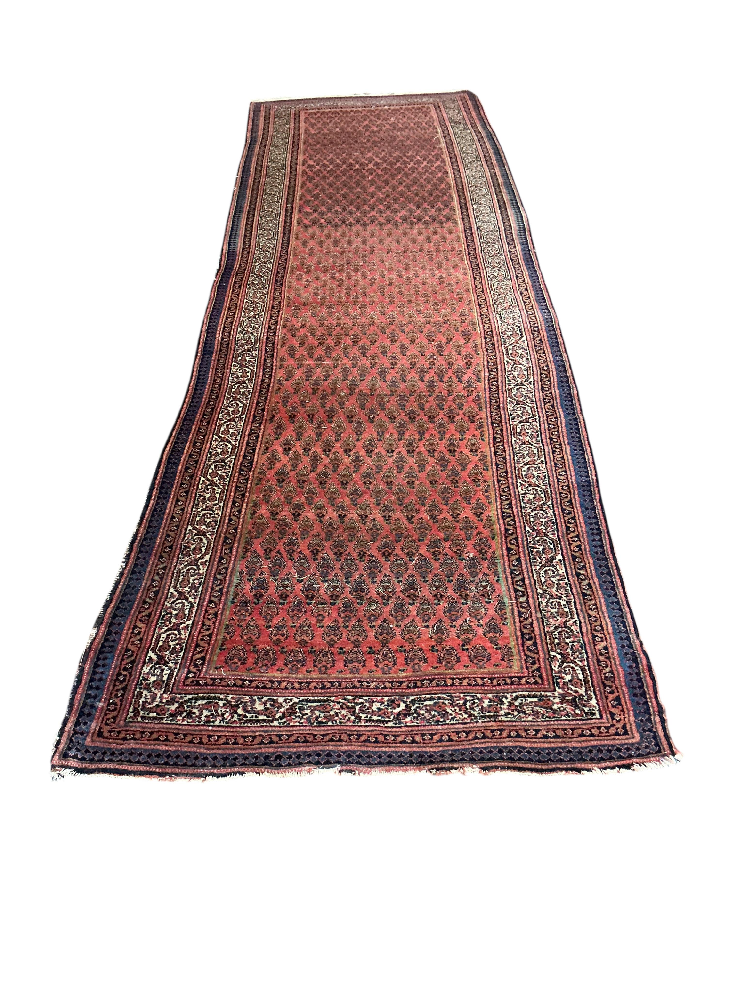 An Ashfar red ground runner, with all over boteh design, 360 x 108cm